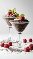Delicious chia seed pudding served in elegant glass cups with fresh raspberries and mint leaves photo