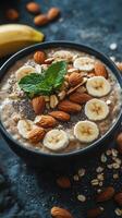 Healthy breakfast bowl with oats, banana slices, nuts, and seeds on a dark wooden table photo