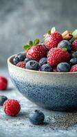 Fresh and vibrant mixed berries served in a textured bowl on a rustic countertop photo
