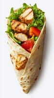 Grilled chicken wrap filled with fresh vegetables and greens in a soft tortilla photo