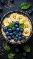 Healthy breakfast bowl filled with bananas, blueberries, and chia seeds arranged beautifully on a dark surface photo