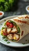 Delicious chicken burrito wrapped in a tortilla with fresh vegetables at a dining table photo