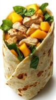Grilled chicken and mango wrap featuring fresh spinach served on a white background for a healthy meal option photo