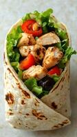 Freshly made grilled chicken wrap with vegetables served on a light background during lunchtime photo