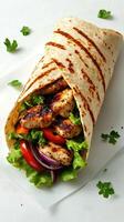 Grilled chicken wrap filled with fresh vegetables and greens served on a plain background photo