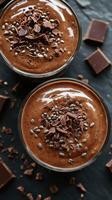 Decadent chocolate mousse topped with shavings and sprinkles served in elegant glass bowls photo