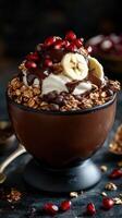 Delicious granola bowl topped with yogurt, banana slices, pomegranate, and chocolate drizzle photo