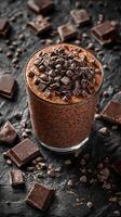 Delicious chocolate smoothie topped with chocolate pieces on a dark textured surface photo