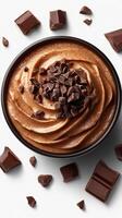 Delicious chocolate mousse topped with dark chocolate shavings and chunks on a white background photo