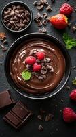 Delicious chocolate mousse with berries and mint on a slate surface photo