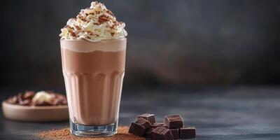Creamy chocolate drink topped with whipped cream and chocolate shavings served in a glass photo