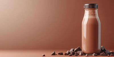 Chocolate milk in a glass bottle surrounded by chocolate chunks on a minimalist background photo