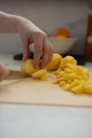 Carefully chop fresh potatoes in a bright and modern kitchen today photo