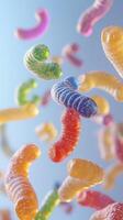 Colorful gummy worms cascading against a blue background creating a playful and vibrant display photo