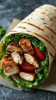 Delicious grilled chicken wrap with fresh vegetables on a rustic table photo