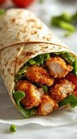 Delicious crispy chicken wrap with fresh lettuce and tomatoes in a soft tortilla served on a plain background photo
