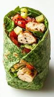 Fresh spinach wrap filled with grilled chicken, vegetables, and sesame seeds served on a white background photo