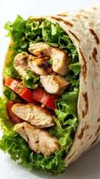 Freshly made chicken wrap filled with greens and tomatoes ready to be enjoyed for lunch photo