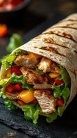 Grilled chicken wrap filled with fresh vegetables and wrapped in a warm tortilla photo