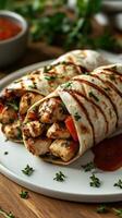Delicious grilled chicken wraps served on a plate with fresh herbs and dipping sauce photo