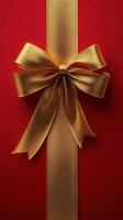 Bright red gift wrap adorned with a shiny gold bow for holiday celebrations or special occasions in a festive setting photo