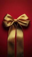 Elegant gold ribbon bow on vibrant red background for festive occasions photo