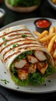 Grilled chicken wrap served with crispy fries and dipping sauce on a white plate in a casual dining setting photo