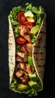 Grilled chicken wrap filled with fresh vegetables served on a dark background photo