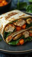 Delicious wrap filled with grilled chicken, spinach, and diced carrots served on a plate for a healthy meal option photo