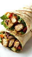Grilled chicken wrap filled with fresh vegetables and greens served in a soft tortilla photo