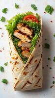 Delicious grilled chicken wrap filled with fresh lettuce and tomatoes on a textured surface photo