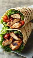 Grilled chicken wraps with fresh lettuce and tomatoes served on parchment paper photo