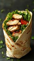 Grilled chicken wrap with fresh lettuce and tomato served on a dark background photo