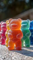 Colorful gummy bears arranged in a playful formation under bright sunlight in an outdoor setting photo