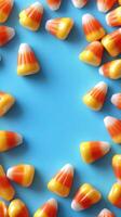 Colorful candy corn scattered on a bright blue background creates a festive autumn atmosphere photo