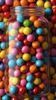 Colorful gumballs in a glass jar surrounded by more gumballs in a vibrant display photo