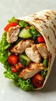 Fresh chicken wrap filled with vegetables and greens presented on a neutral background photo