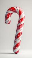 Colorful candy cane with realistic droplets on surface displayed against plain background photo
