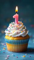 Celebrating a first birthday with a colorful cupcake topped with a single pink candle photo