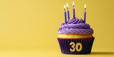 Celebrating a milestone birthday with a vibrant cupcake topped with purple frosting and candles photo