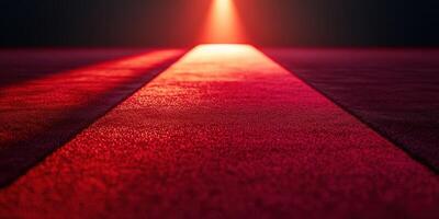 Bright red carpet leading to a spotlight in a dark setting, creating a dramatic atmosphere for an event photo