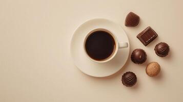 Top view of coffee mug with saucer and chocolates on beige background photo