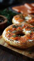 Delicious homemade bagels topped with cream cheese and smoked salmon on a rustic wooden board with herbs photo