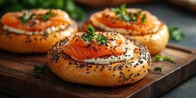Freshly baked bagels topped with cream cheese and smoked salmon served on a wooden board photo