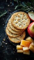 Savory crackers paired with fresh apple slices and sweet fruit preserves on a dark textured surface photo