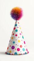 Colorful party hat with pom pom on top displayed against a plain background photo