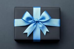 Black Gift Box with Blue Ribbon Bow Black Background photo