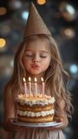 Young girl celebrating a birthday with a beautiful cake and candles in a festive setting photo