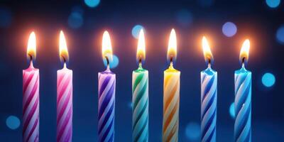 Colorful birthday candles lit against a blurred blue background creating a festive atmosphere during a celebration photo