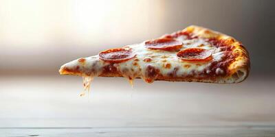 Perfectly melted cheese and pepperoni slice suspended in mid-air with a blurred background during daylight photo